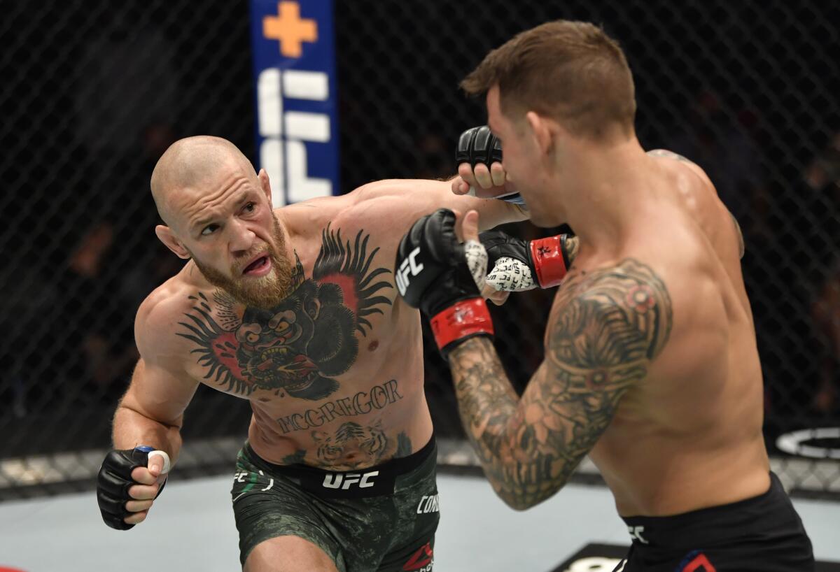 Conor McGregor punches Dustin Poirier during their lightweight fight at UFC 257 on Saturday.