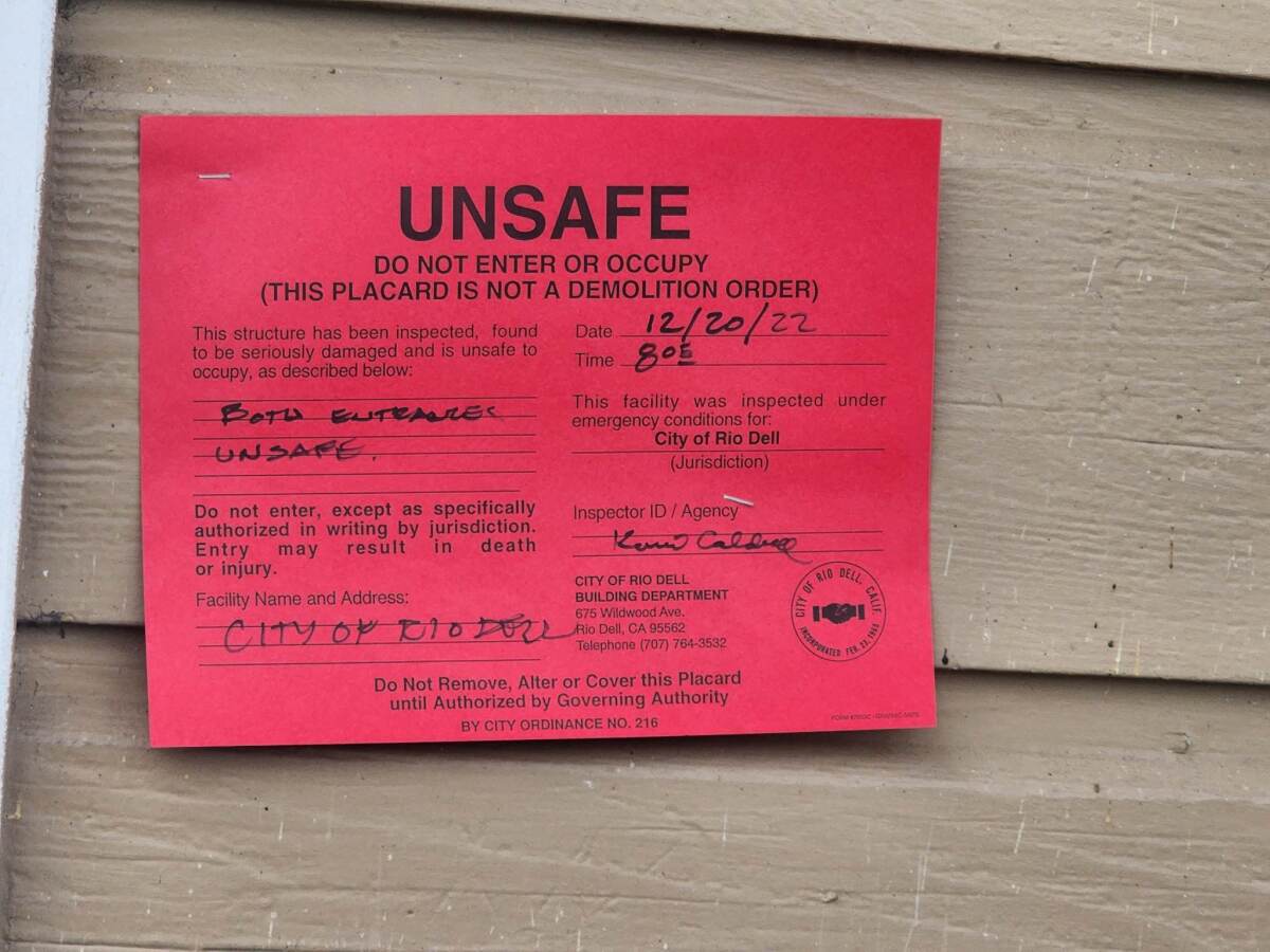 A red sign declares a home unsafe. 