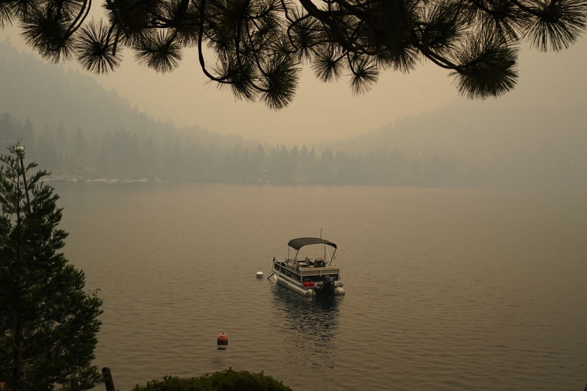 A boat on a lake amid smoke.
