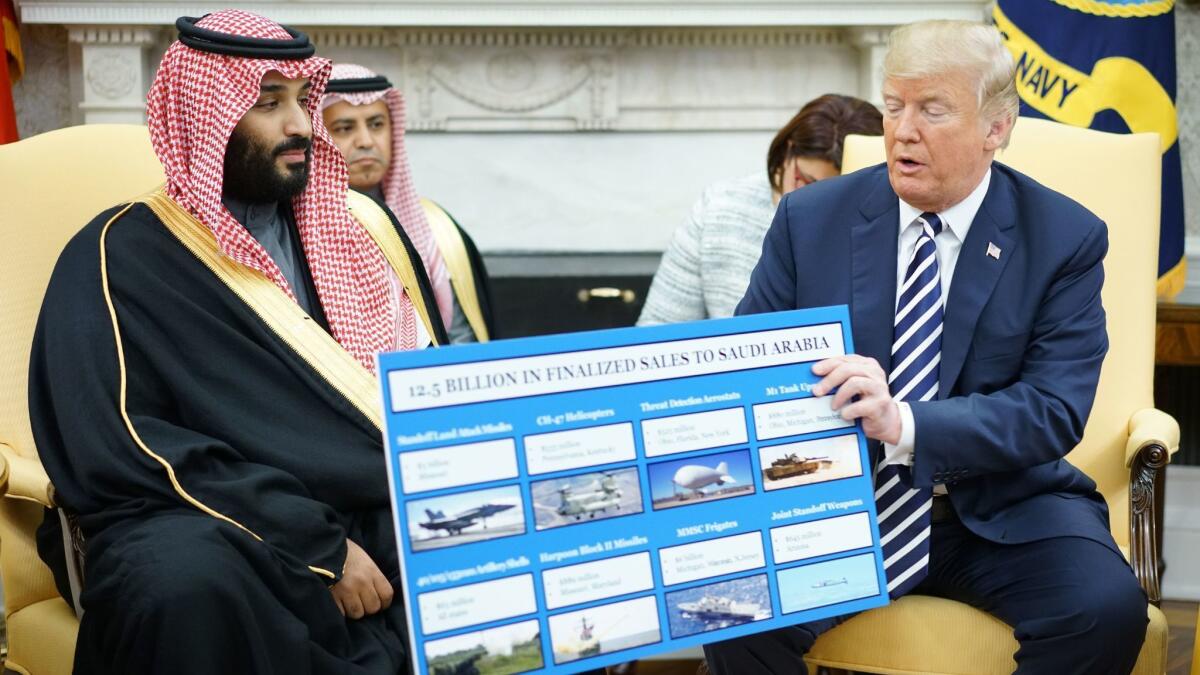 President Trump holds a defense sales chart during a meeting with Crown Prince Mohammed bin Salman of Saudi Arabia in the White House on March 20, 2018.