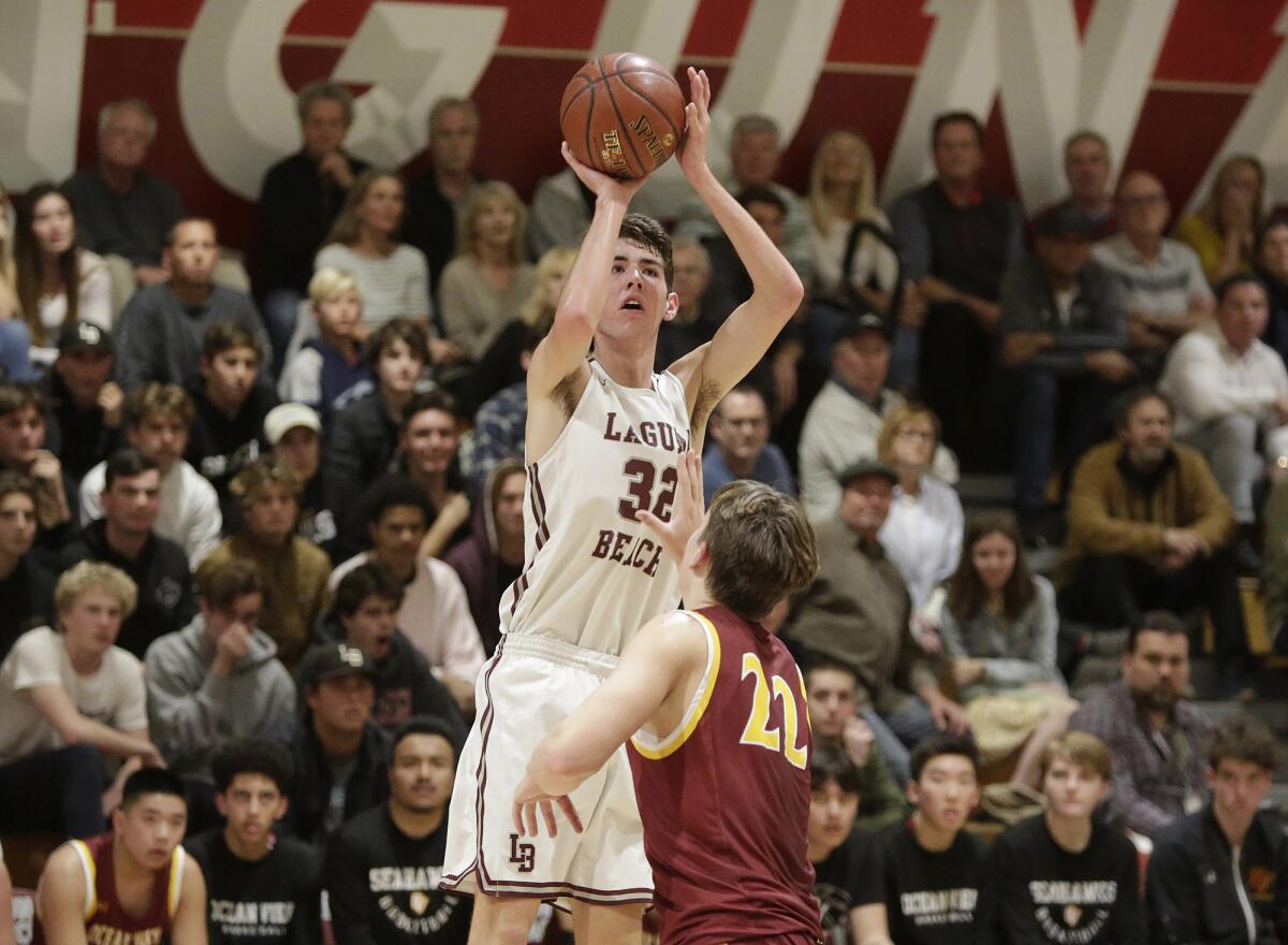 Laguna Beach's Nolan Naess shoots a jumper as Ocean View’s Slater Miller defends in the first round of the CIF Southern Section Division 3AA playoffs on Wednesday.