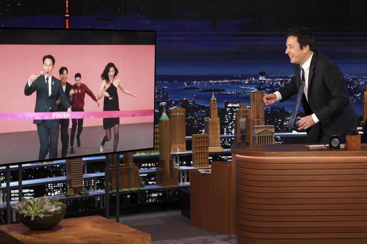 Jimmy Fallon, at his desk, speaks to the "Squid Game" cast via video.