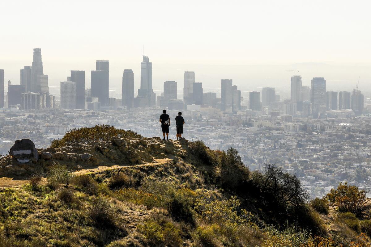 Hikers take in the views of the Los Angeles skyline from Griffith Park. 