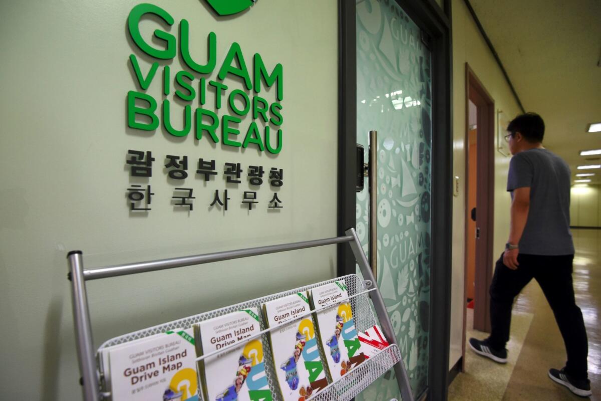 A man walks past the Seoul office of the Guam Visitors Bureau in Seoul.