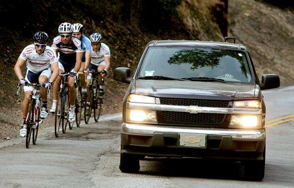 A passing pickup truck straddles the center divider while sharing the road with bicyclists on Mandeville Canyon Road in Brentwood, where a local resident allegedly slammed on his brakes in front of two bicyclists, injuring both seriously, on July 4. "Sometimes motorists don"t know how close they are," says Marco Fantone of the Velo Club LaGrange cycling organization.