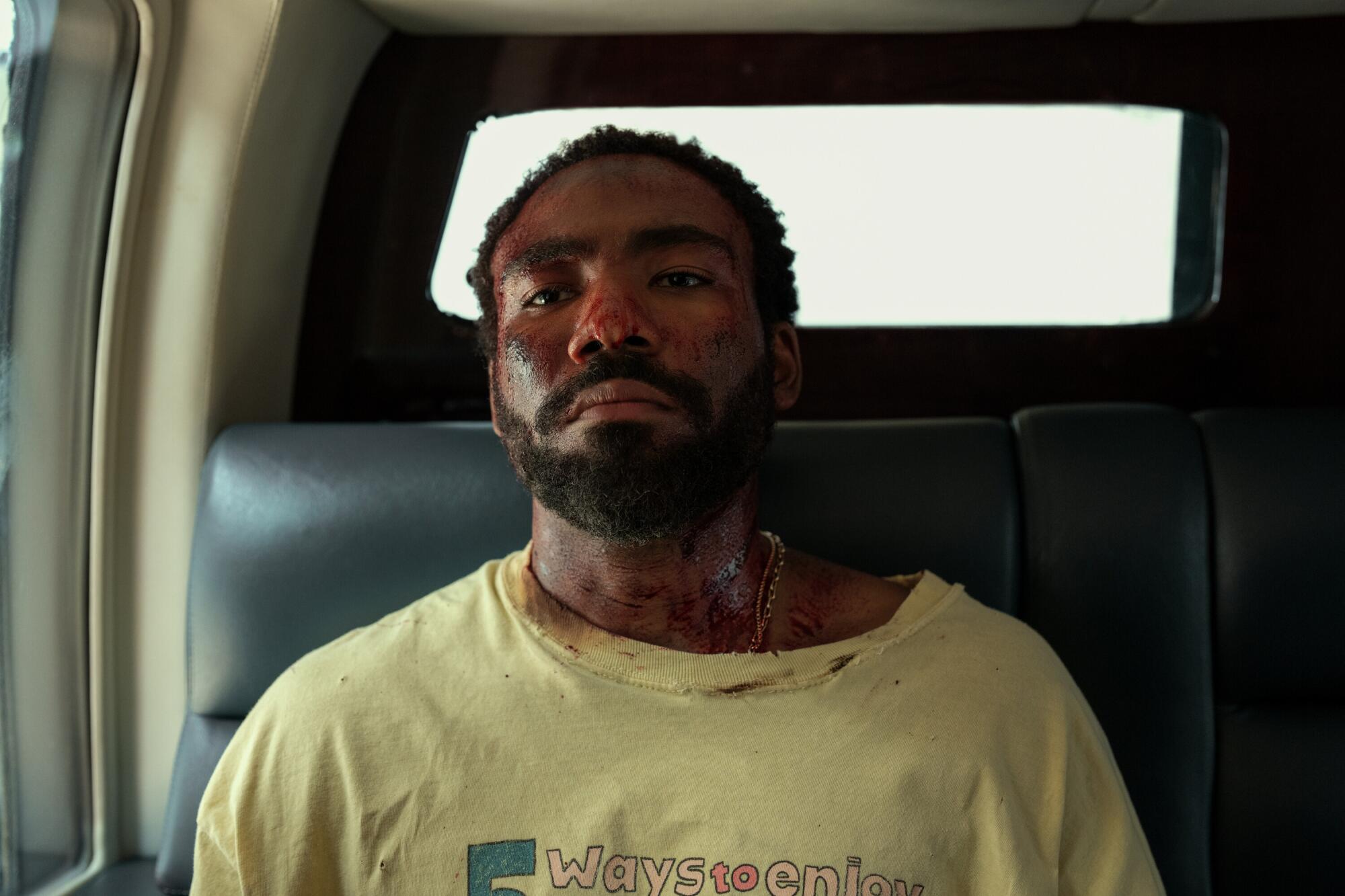 A bloodied man sits in a car in "Mr. & Mrs. Smith."