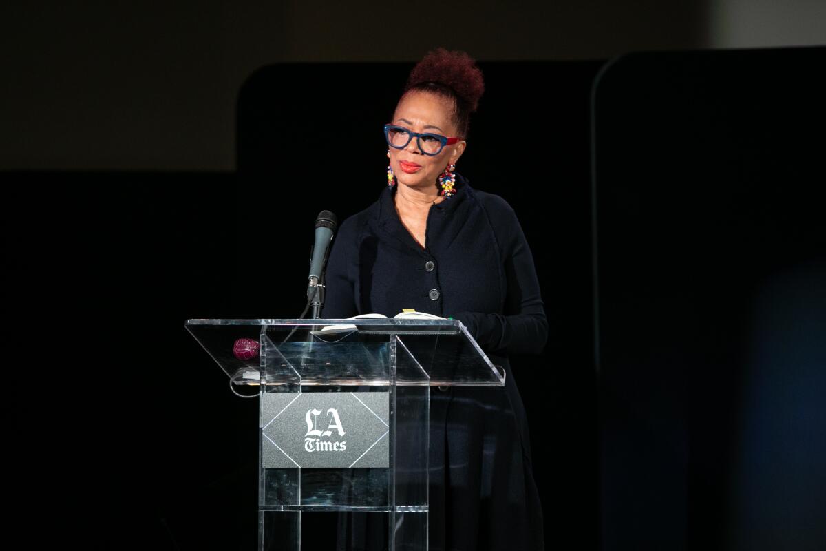 A woman stands at a lectern.