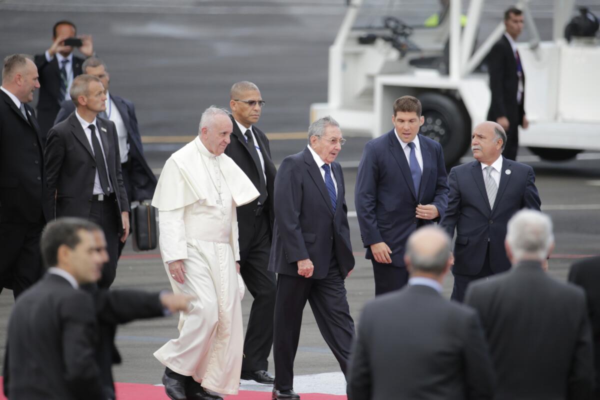 Rodeado de agentes de seguridad, el papa Francisco camina con el presidente cubano Raúl Castro al llegar a La Habana, Cuba, el sábado 19 de septiembre de 2015. El papa Francisco inicia su viaje de diez días a Cuba y Estados Unidos el sábado, embarcándose en su primer viaje a los países alguna vez rivales de la Guerra Fría para animar su histórica reconciliación.