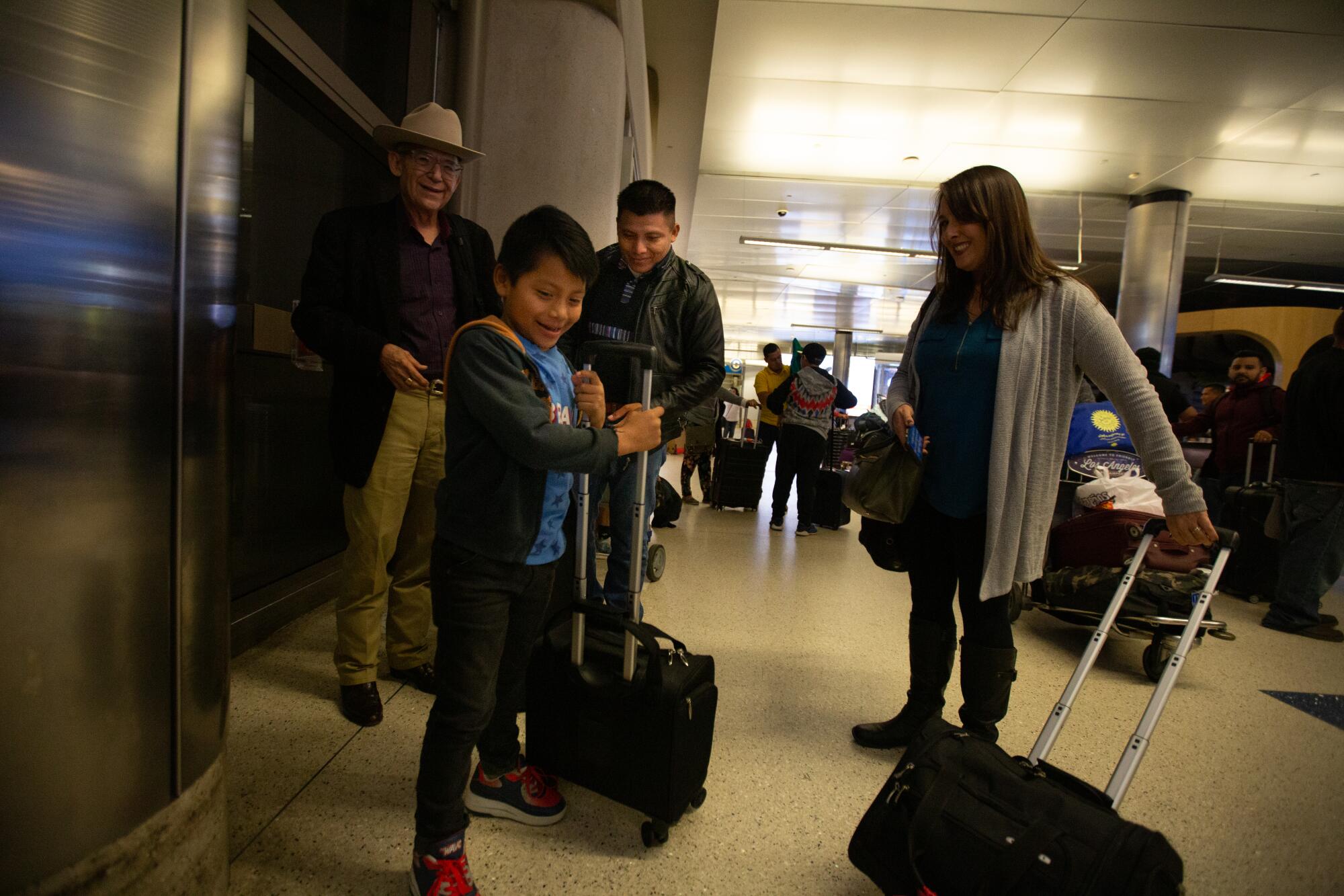 Byron Xol, 9, helps his dad David Xol with his luggage upon his return to the U.S.