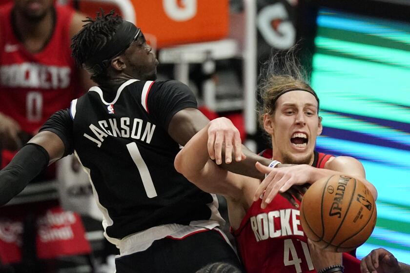 Los Angeles Clippers guard Reggie Jackson, left, and Houston Rockets forward Kelly Olynyk battle for a rebound during the first half of an NBA basketball game Friday, April 9, 2021, in Los Angeles. (AP Photo/Mark J. Terrill)