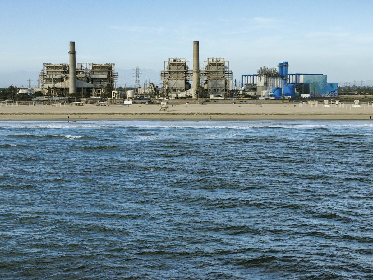 Ocean water in the foreground and industrial buildings in the background.