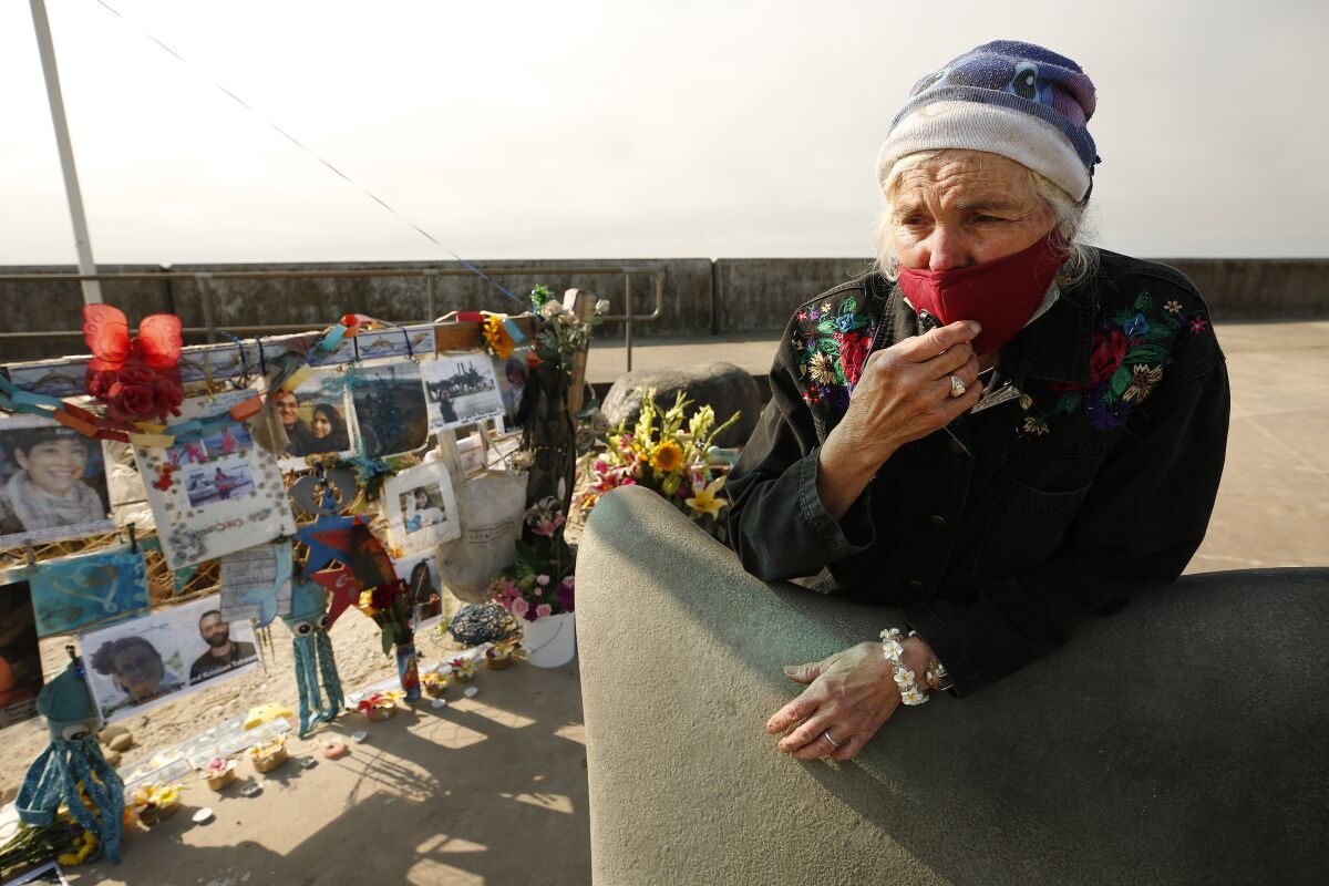 A woman and a memorial for victims of the Conception boat disaster