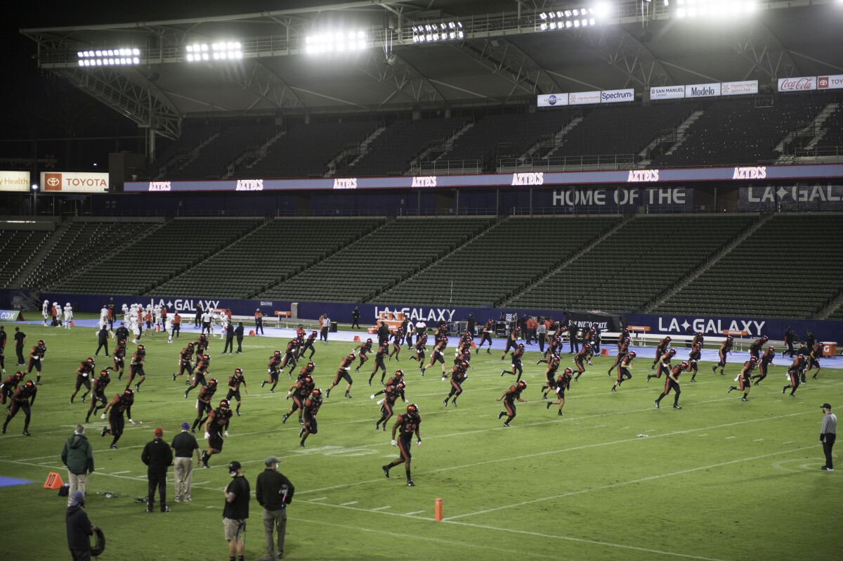 San Diego State warms up under the lights of a near empty stadium.