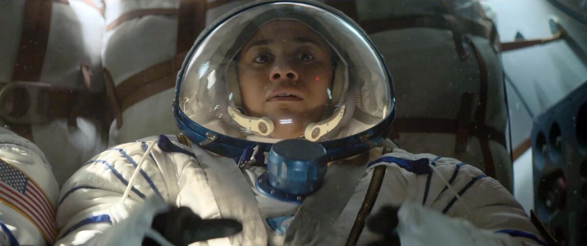 A woman astronaut looks nervous in a pressure suit.