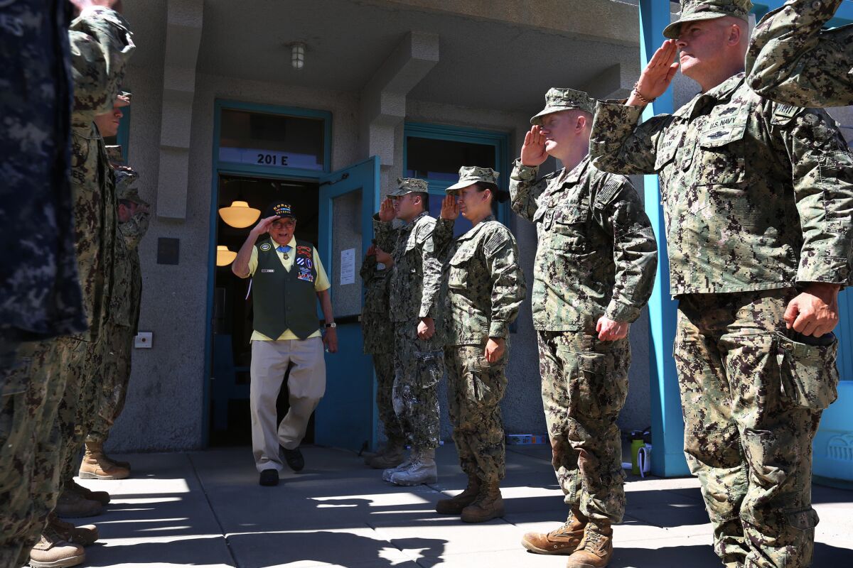 Hiroshi Miyamura is saluted by a group of Navy Seabees after he spoke to them about his war experiences at the Gallup Cultural Center.