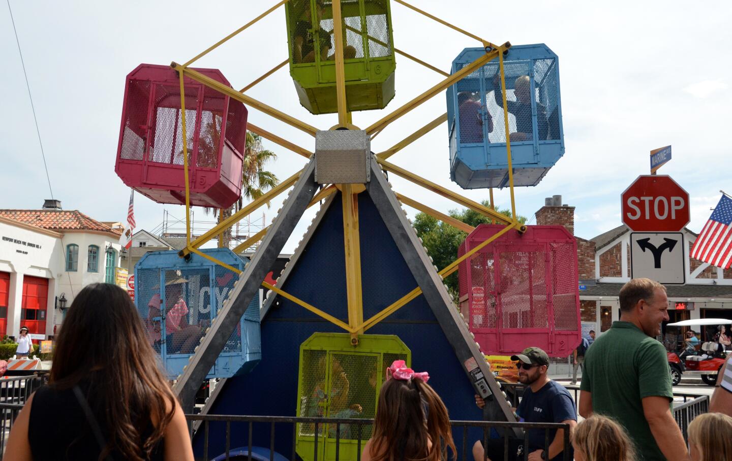 Kids ride the miniature Ferris wheel at Sunday's Balboa Island Carnival & Taste of the Island on Marine Avenue.
