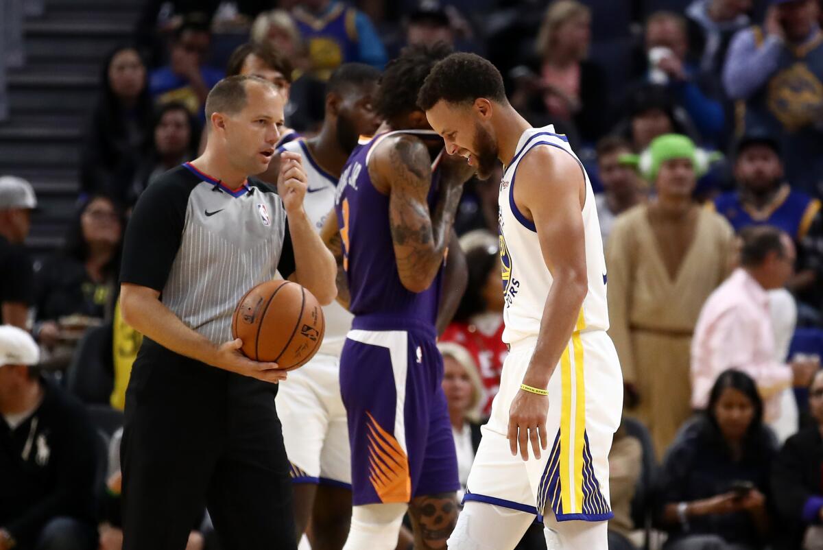 Warriors guard Stephen Curry grimaces after he fell to the court and broke his left hand during the second half of a game against the Suns at Chase Center on Oct. 30, 2019 in San Francisco.