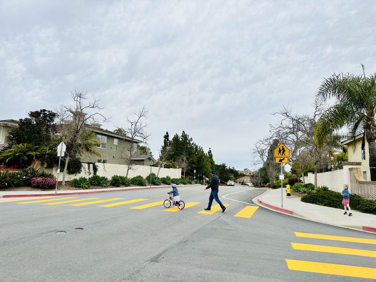 Jonathan Altschul crosses Ashley Falls Drive and Pearlman Way with daughters Juliette and Charlotte.