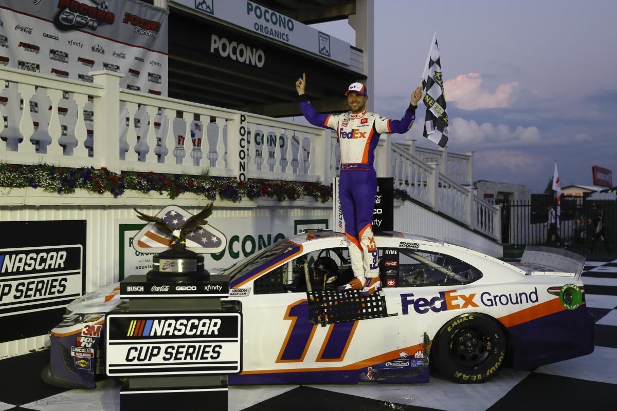 Denny Hamlin celebrates after winning the NASCAR Cup Series auto race at Pocono Raceway.
