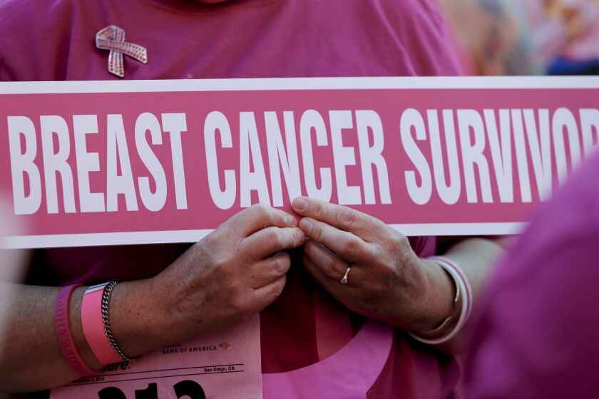 Shelly Herndon held a sign as a cancer survivor for the opening ceremony at the Susan G. Komen, Race for the Cure 2019 at Balboa Park on Sunday, November 3, 2019.