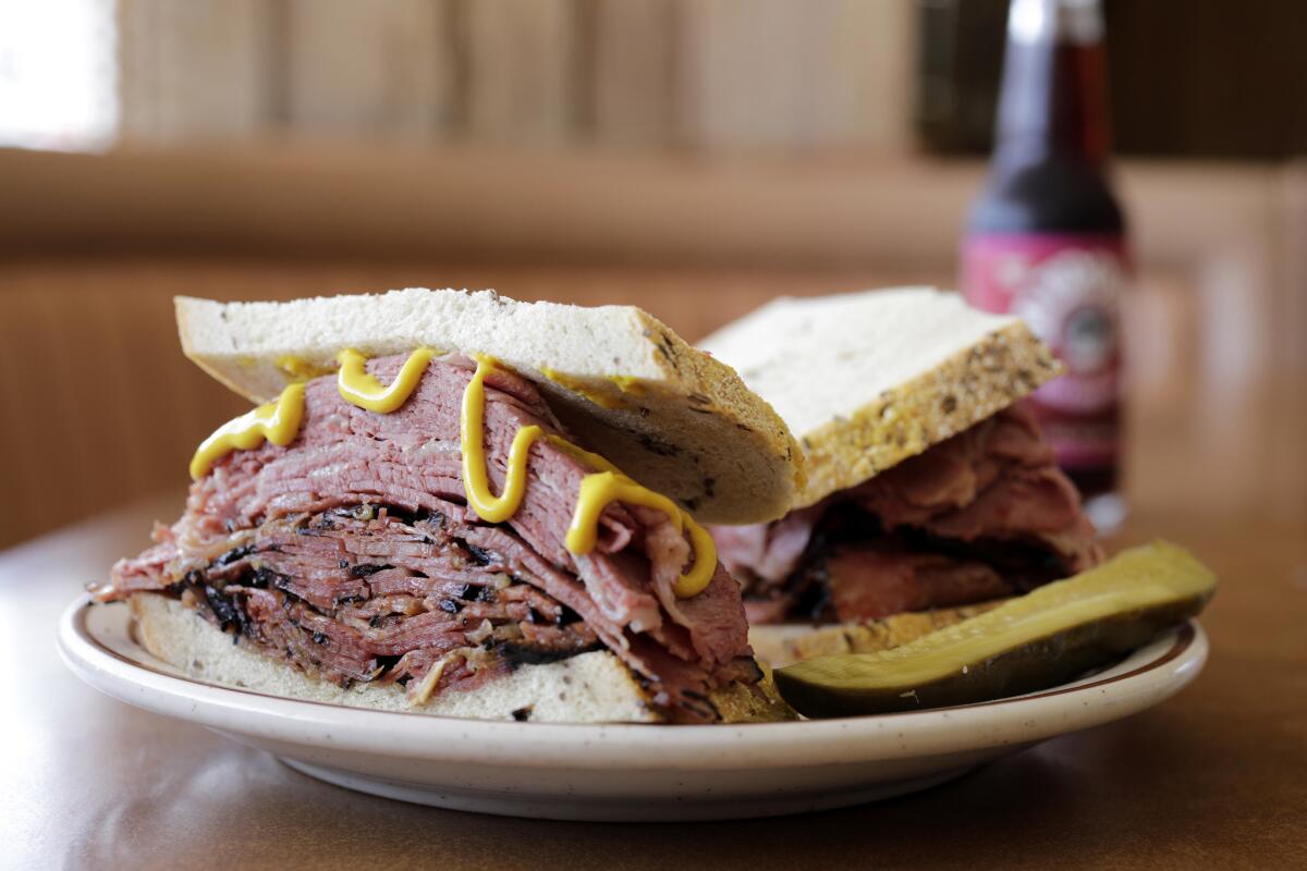 Canter's Fairfax Sandwich features hot corned beef and pastrami on rye bread with a choice of cole slaw or potato salad.