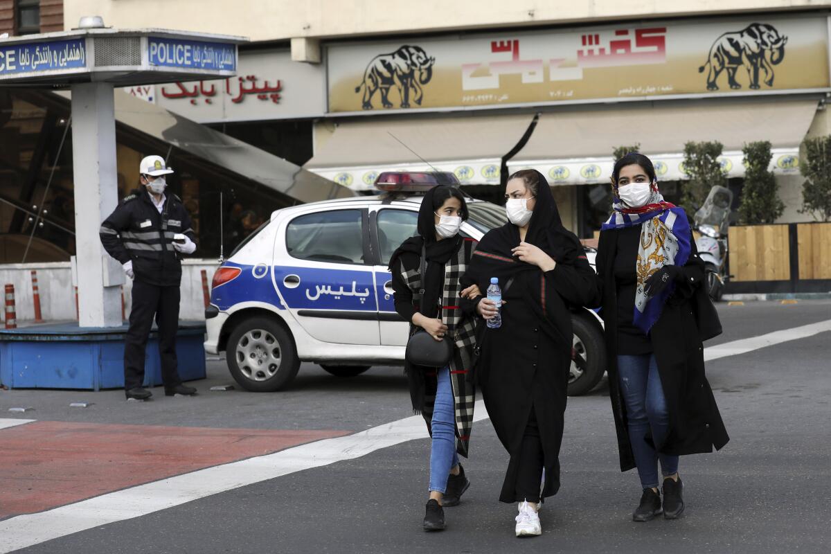 People wearing masks wait to cross a street Feb. 2 in Tokyo.