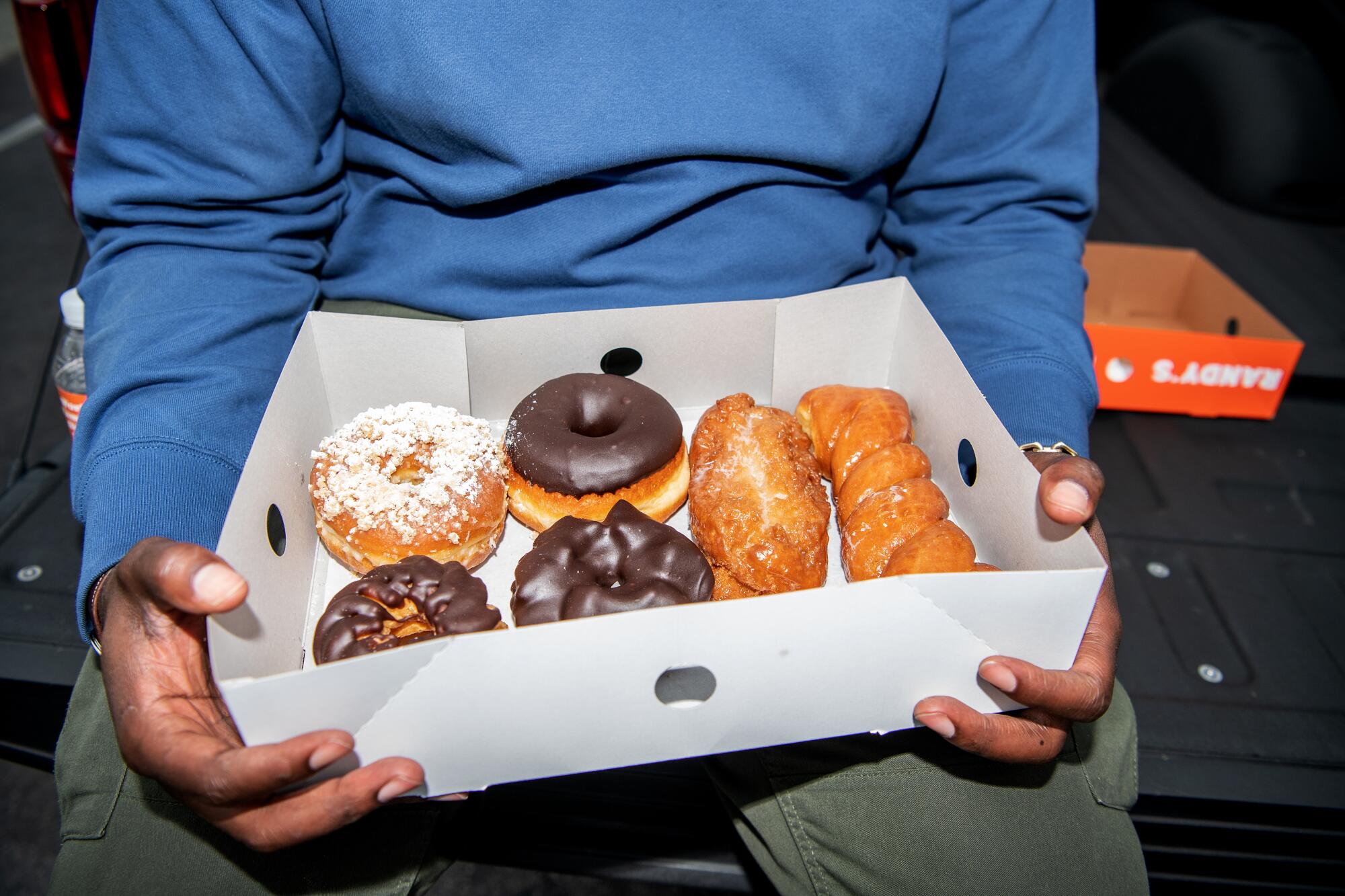 Lionel Boyce holds a box of doughnuts at Randy's Donuts