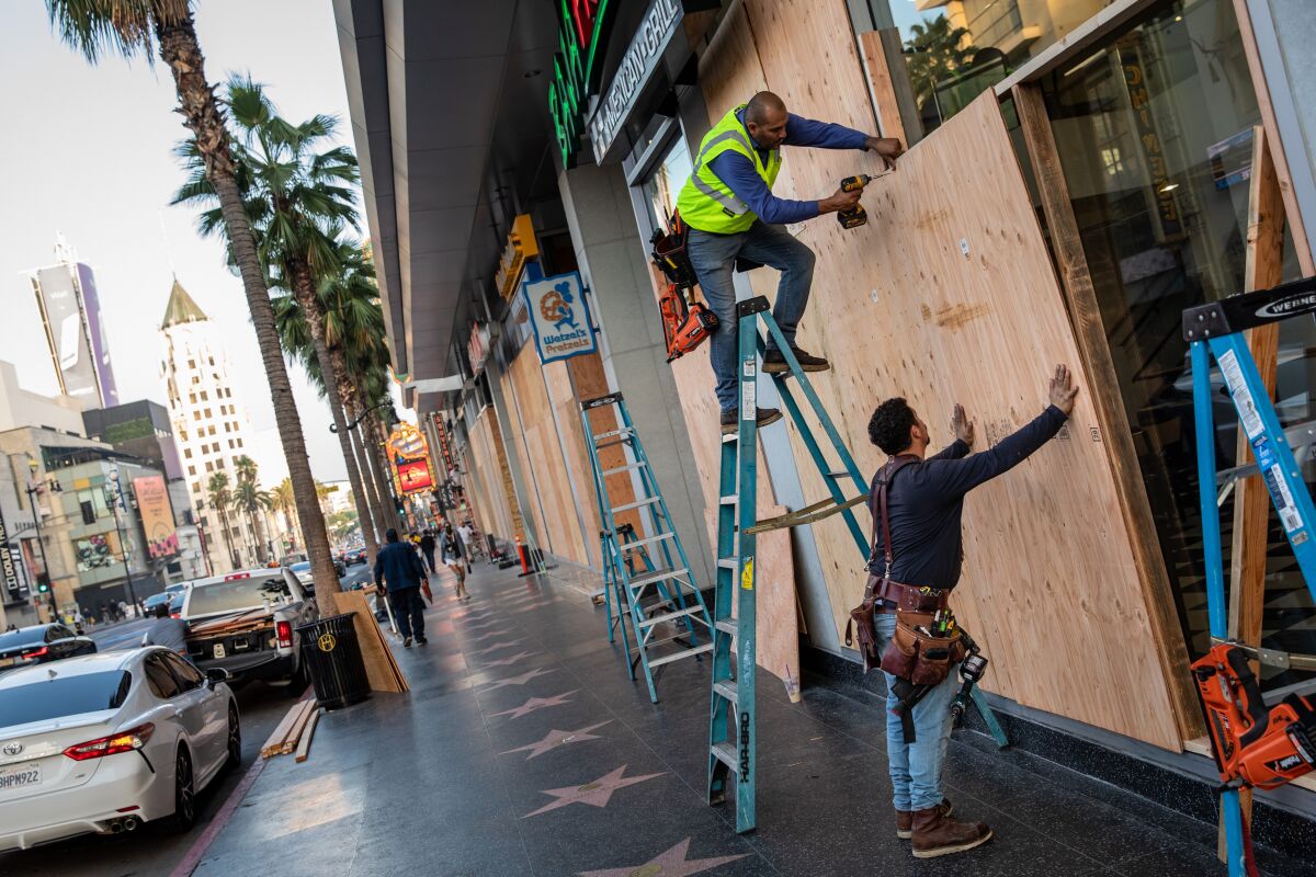Workers secure plywood to protect windows along Hollywood Boulevard in Hollywood, CA, on election night