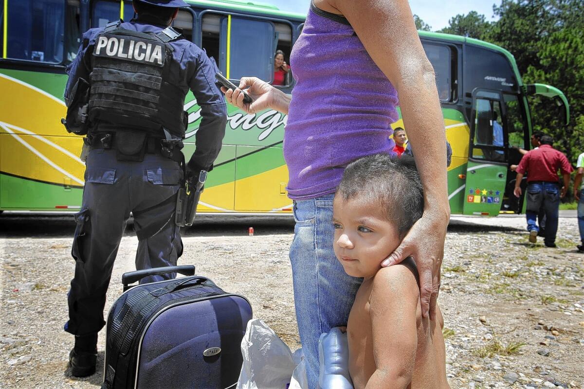 Jose Pineda Ramos, 2, clings to his mother at a police checkpoint in Ocotepeque, Honduras. The two were making their way to Los Angeles.