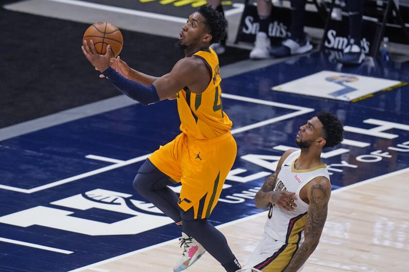 Utah Jazz guard Donovan Mitchell, left, goes to the basket as New Orleans Pelicans guard Nickeil Alexander-Walker defends during the first half of an NBA basketball game Tuesday, Jan. 19, 2021, in Salt Lake City. (AP Photo/Rick Bowmer)