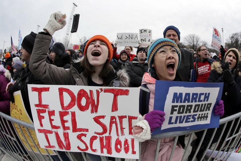 FILE - Demonstrators hold signs during a "March for Our Lives" rally in support of gun control, Saturday, March 24, 2018, in Chicago. In the wake of the shooting at Marjory Stoneman Douglas High School, teenaged survivors organized one of the largest youth protests in history in D.C., rallying over a million activists in sister marches from California to Japan. (AP Photo/Nam Y. Huh, File)