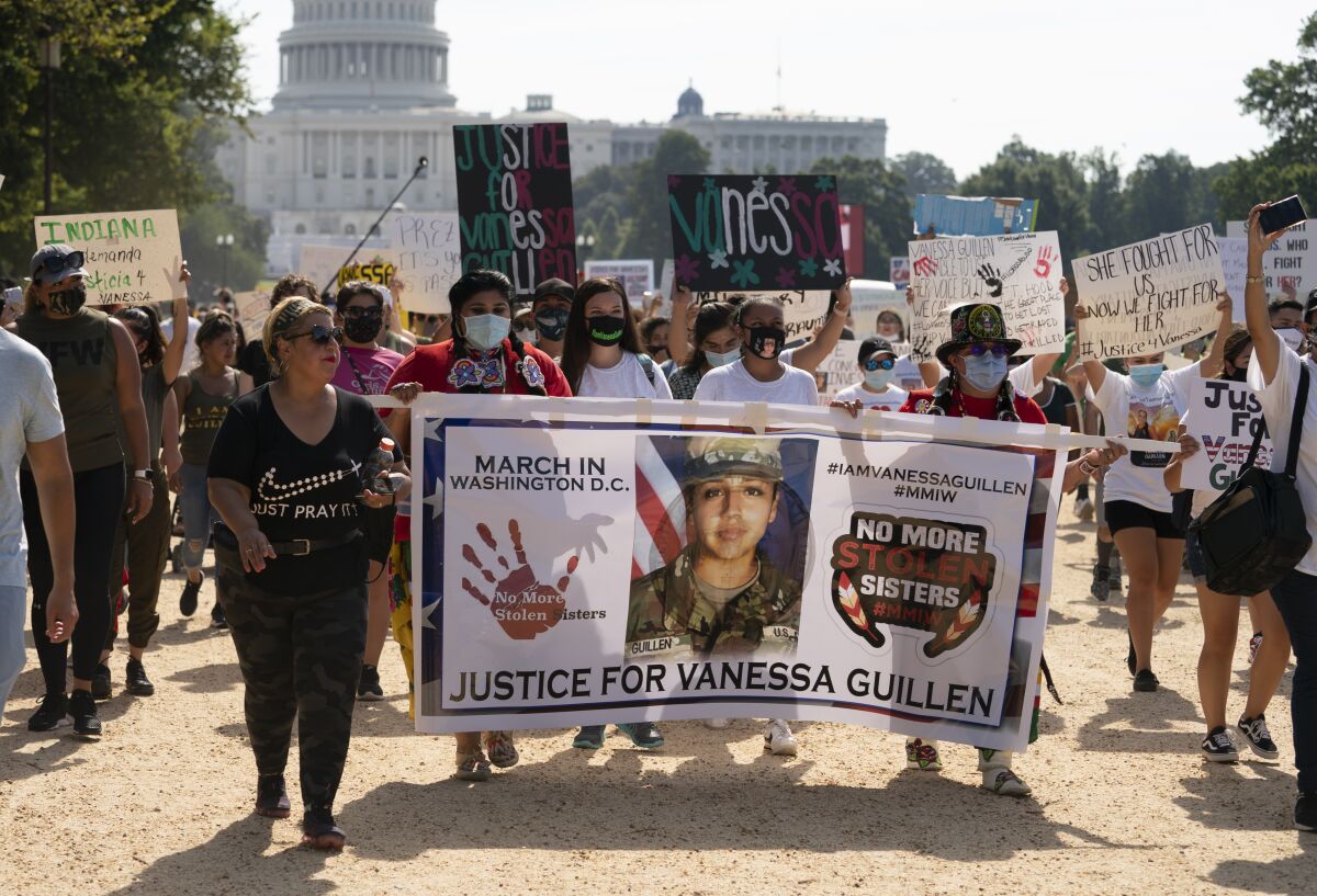 Supporters of the family of slain Army Spc. Vanessa Guillen march to the White House along the National Mall as Capitol Hill is seen in the distance after a news conference, Thursday, July 30, 2020, in Washington. (AP Photo/Carolyn Kaster)