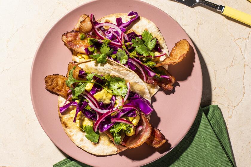 A photograph of Bacon, egg and cheese tacos with Zing! Sauce and pickled onions by Dawn Perry for the Los Angeles Times Week of Meals.