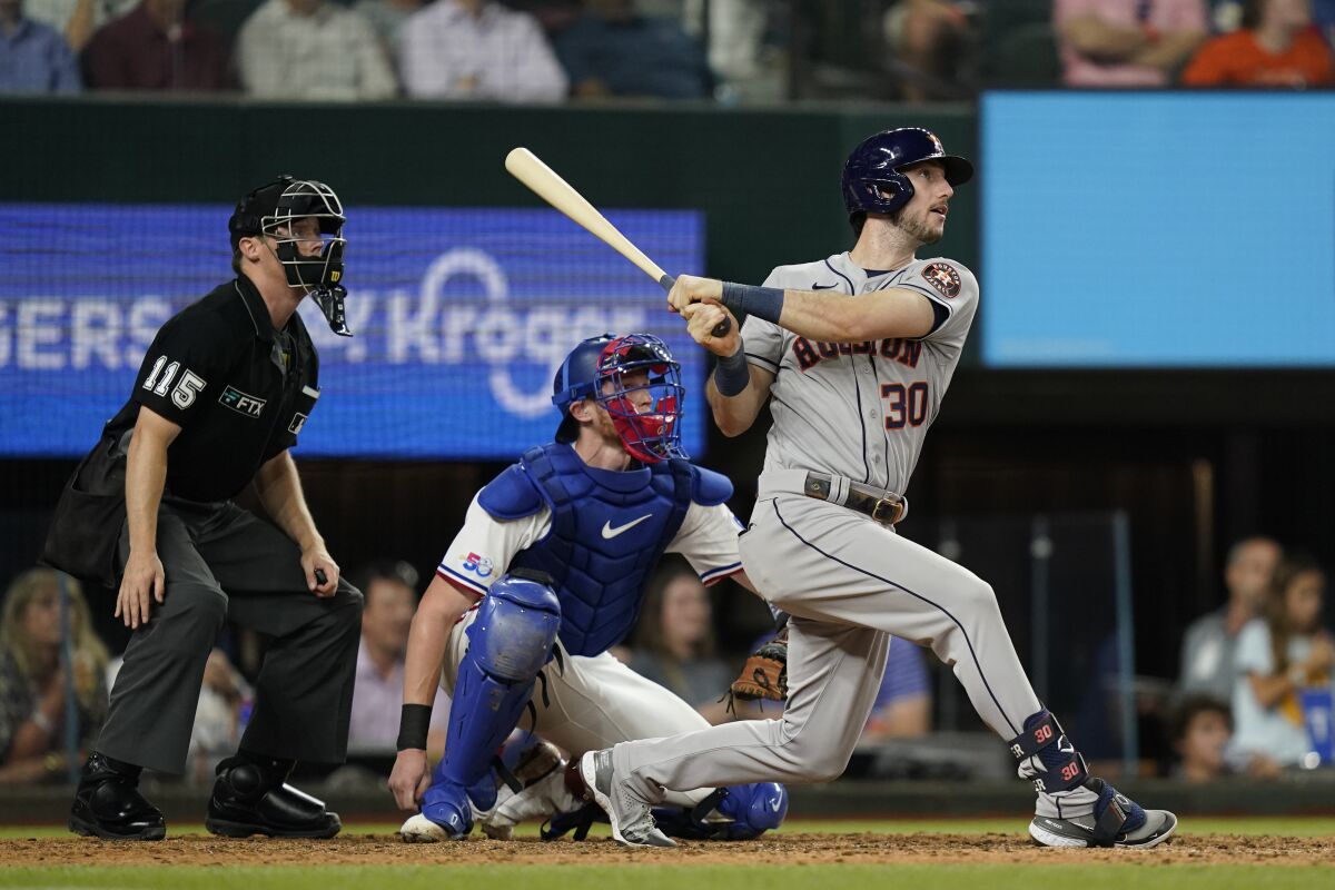 Houston Astros' Kyle Tucker (30) watches his two-run home run, in front of Texas Rangers catcher Sam Huff and home plate umpire Junior Valentine during the eighth inning of a baseball game in Arlington, Texas, Tuesday, June 14, 2022. (AP Photo/LM Otero)