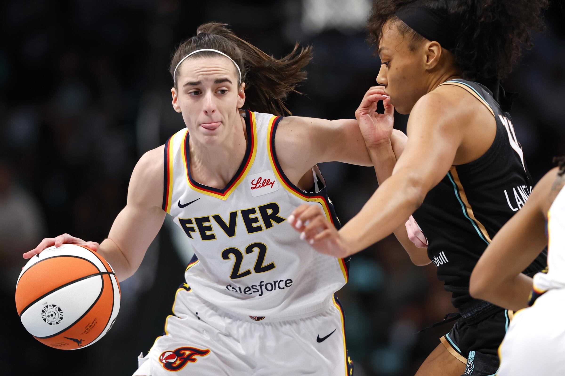 Indiana Fever rookie guard Caitlin Clark drives to the basket in front of New York Liberty forward Betnijah Laney-Hamilton.