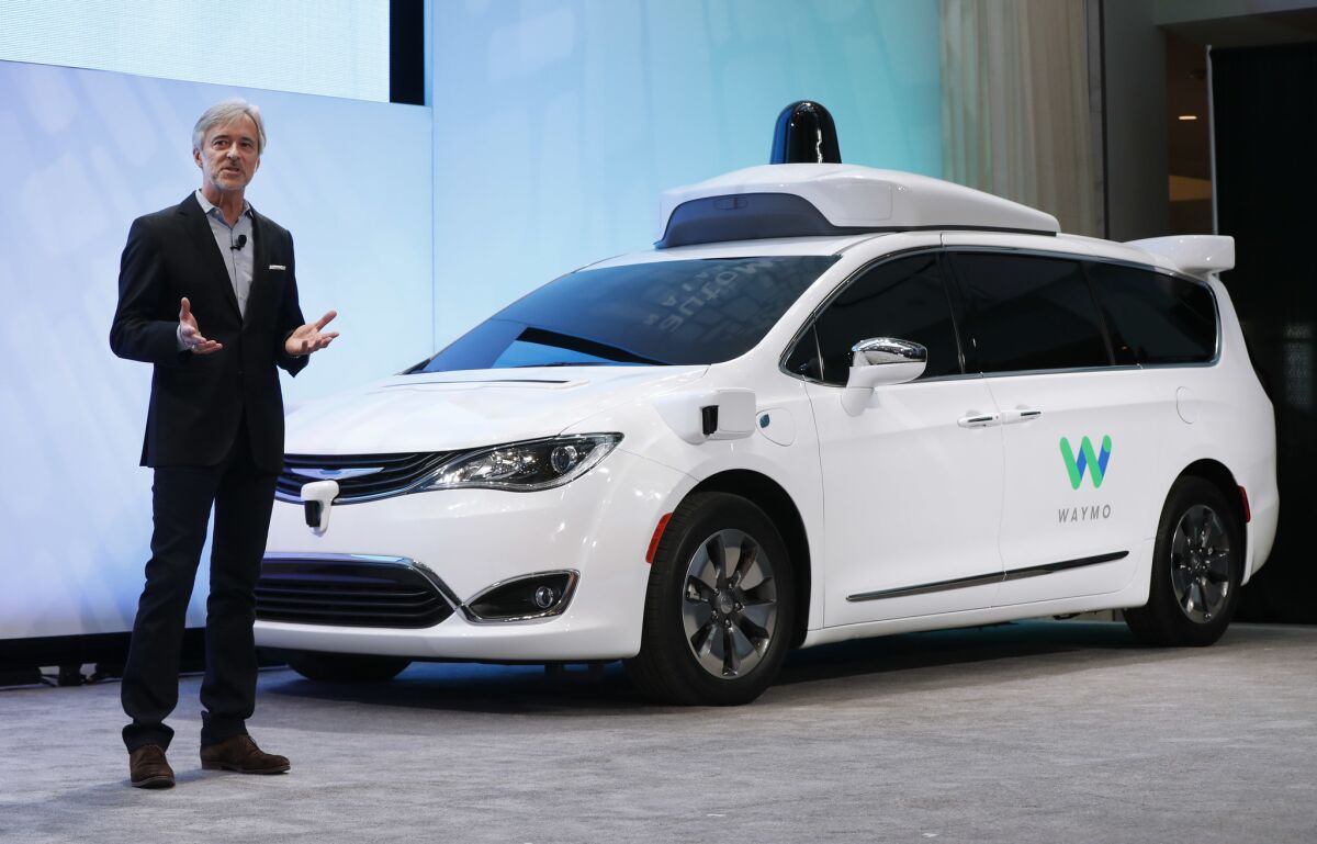 John Krafcik, CEO of Waymo, introduces a self-driving Chrysler Pacifica hybrid at the Detroit auto show.