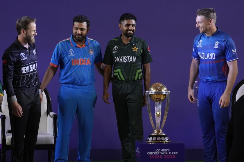 From left, New Zealand's captain Kane Williamson, India's captain Rohit Sharma, Pakistan's captain Babar Azam and England's captain Jos Buttler share a light moment as they pose with the ICC Men's Cricket World Cup trophy in Ahmedabad, India, Wednesday, Oct. 4, 2023. (AP Photo/Rafiq Maqbool)