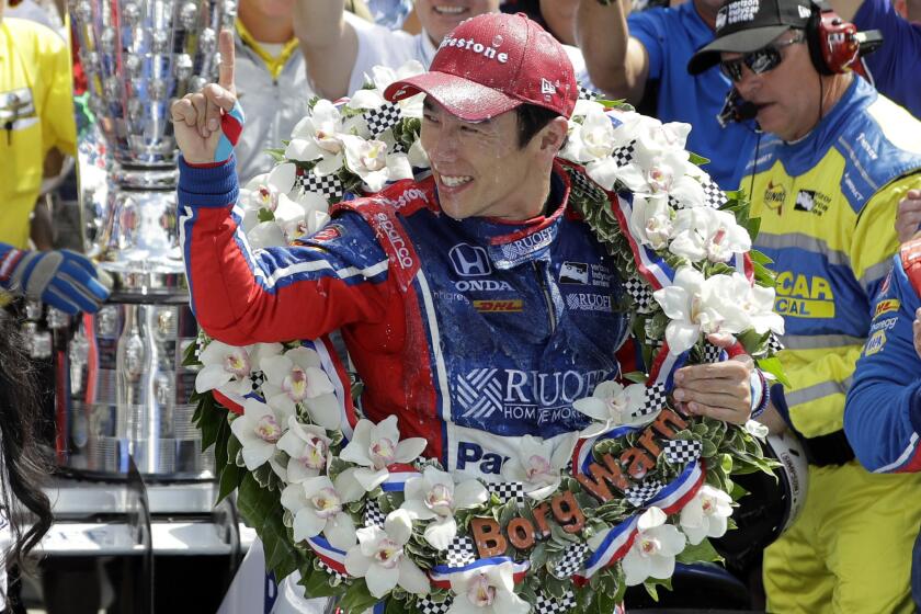 Takuma Sato celebrates after receiving the winner's wreath at the 101st Indianapolis 500.