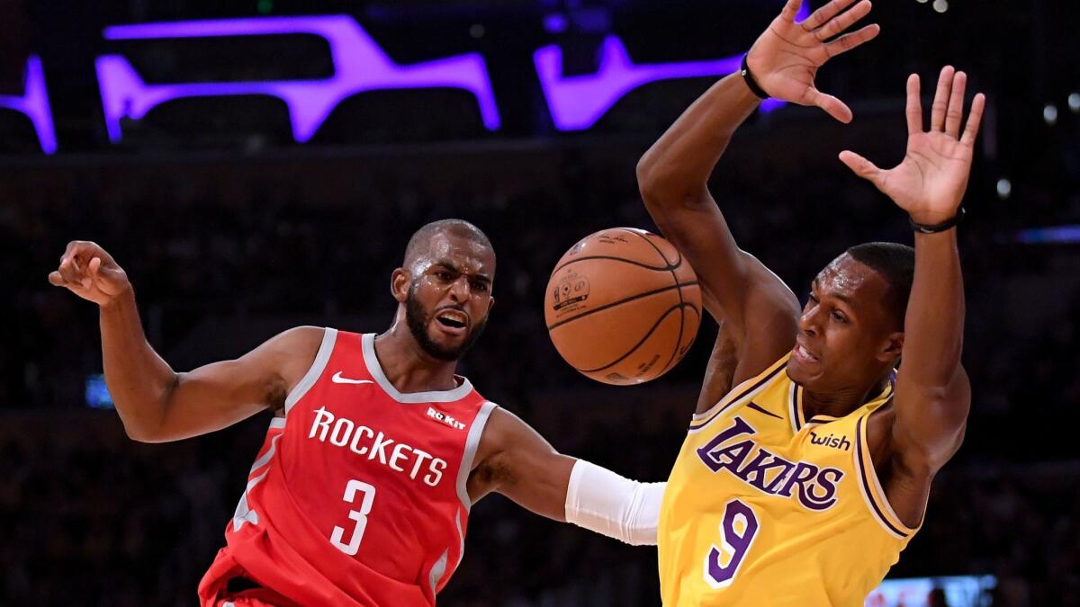 Chris Paul (3) and Rajon Rondo (9) try to maintain their balance after Rondo committed a foul during their game Saturday at Staples Center.