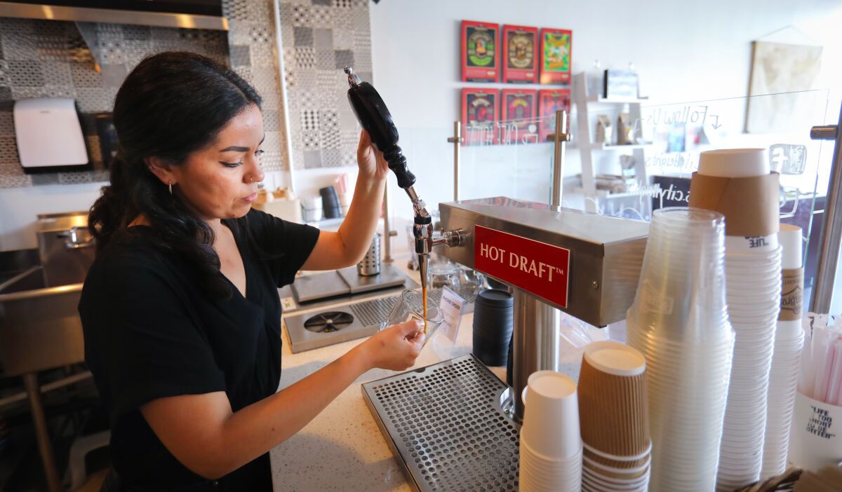 Maxine Zepeda, owner of the Ryan Brothers Coffee location on University Avenue in City Heights, pours a mug of Cowboy Coffee, in her store.
