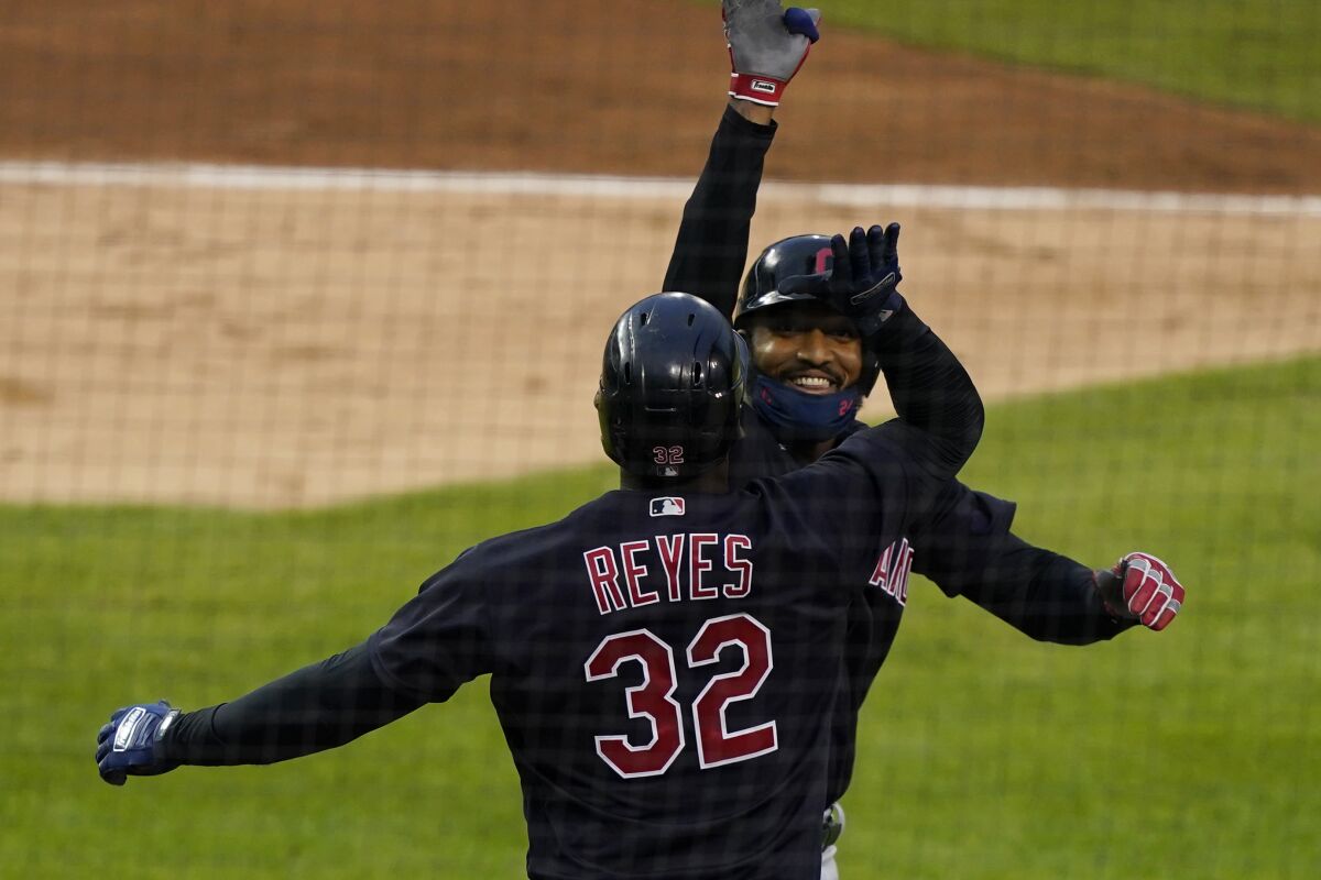 Cleveland Indians' Domingo Santana is greeted by Franmil Reyes after hitting a three-run home run during the fourth inning of a baseball game against the Detroit Tigers, Friday, Aug. 14, 2020, in Detroit. (AP Photo/Carlos Osorio)