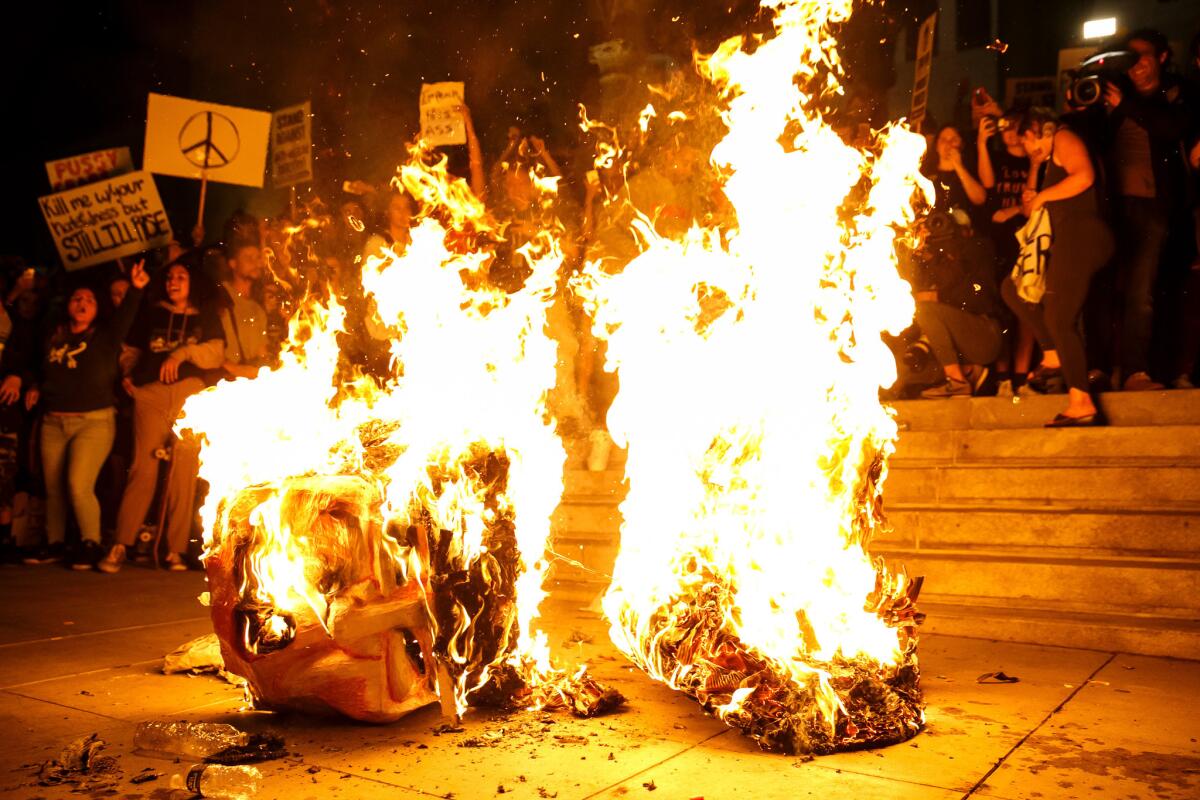 Anti-Trump protesters burn an effigy of the president-elect, Donald Trump, outside City Hall in Los Angeles, Calif., on Nov. 9, 2016.