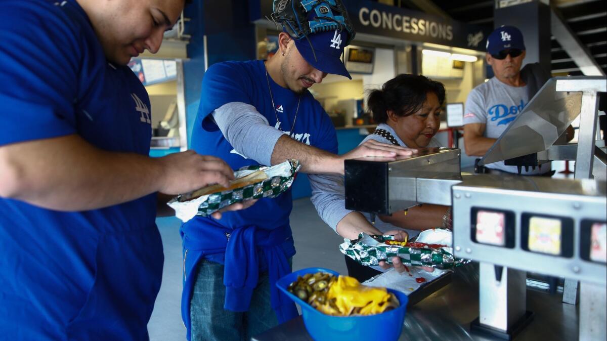 Eric and Steve Soto put condiments on their Dodger Dogs at Dodger Stadium on before a game on May 27. How does the food at Dodger Stadium rank against Petco Park in San Diego?