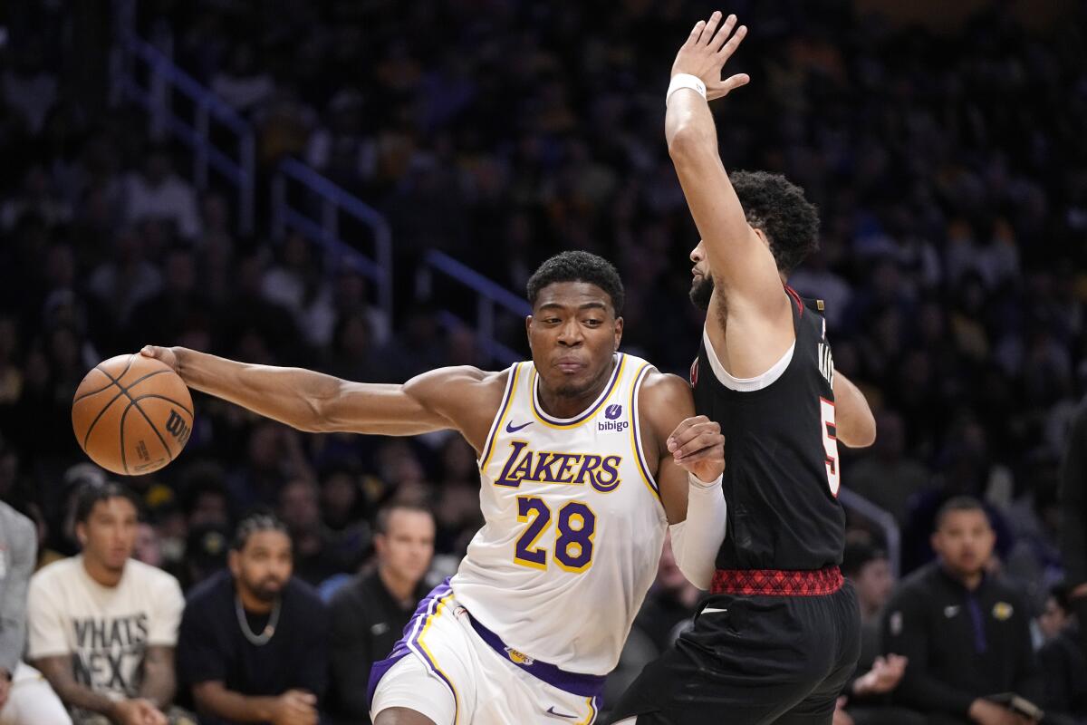 Lakers forward Rui Hachimura, left, drives past Trail Blazers guard Skylar Mays during the first half Sunday.