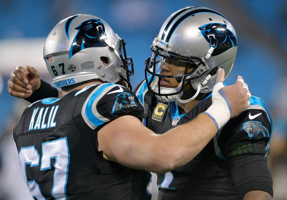 Carolina Panthers quarterback Cam Newton hugs center Ryan Kalil.