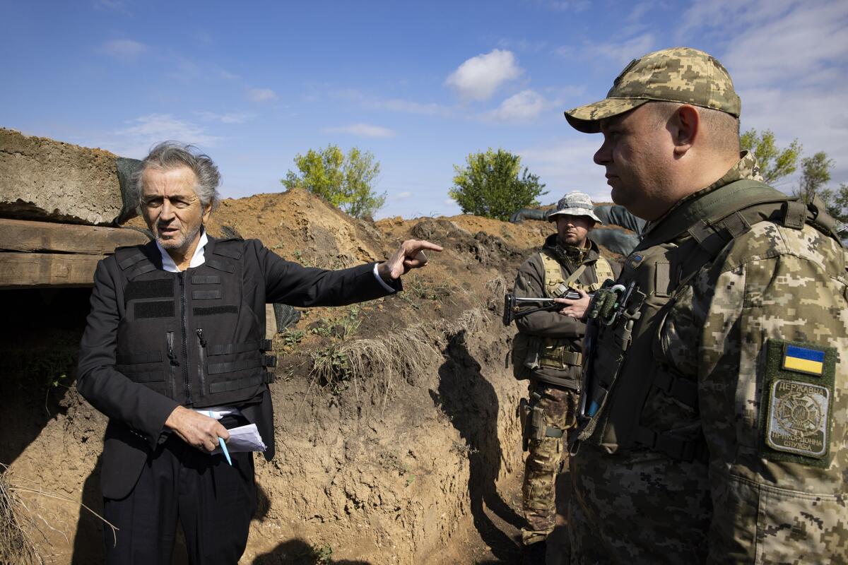 Journalist-filmmaker Bernard-Henri Lévy gestures to Ukrainian soldiers in the documentary "Slava Ukraini."