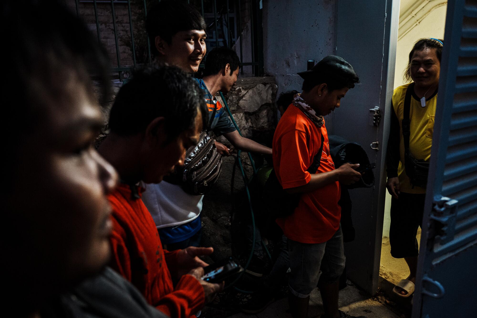 Thai workers linger outside a shelter and an underground bunker after air siren alert.