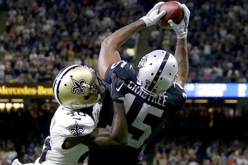 Raiders receiver Michael Crabtree catches the winning two-point conversion pass over Saints defensive back Delvin Breaux on Sunday.