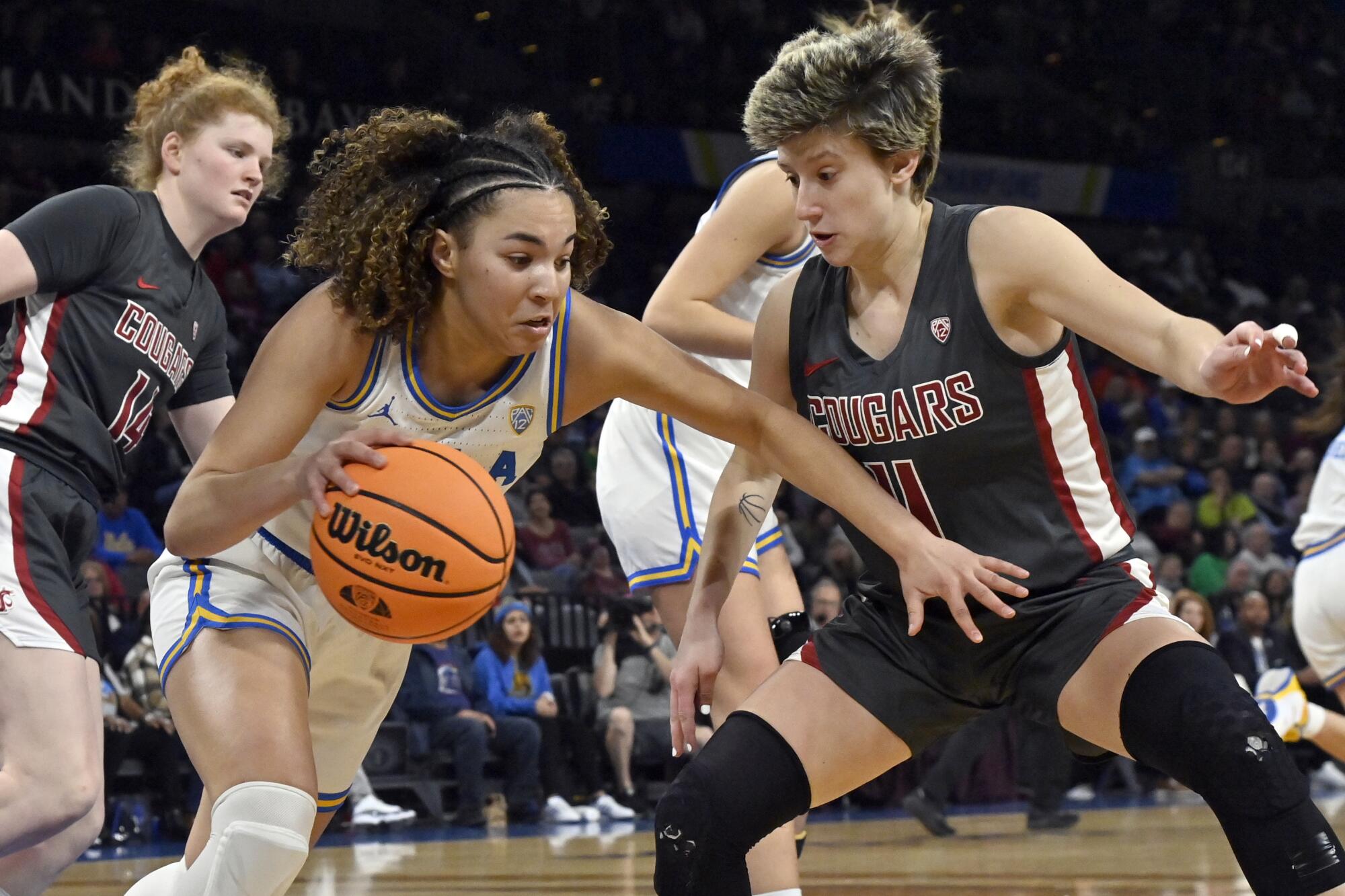 UCLA guard Kiki Rice drives past Washington State guard Astera Tuhina 