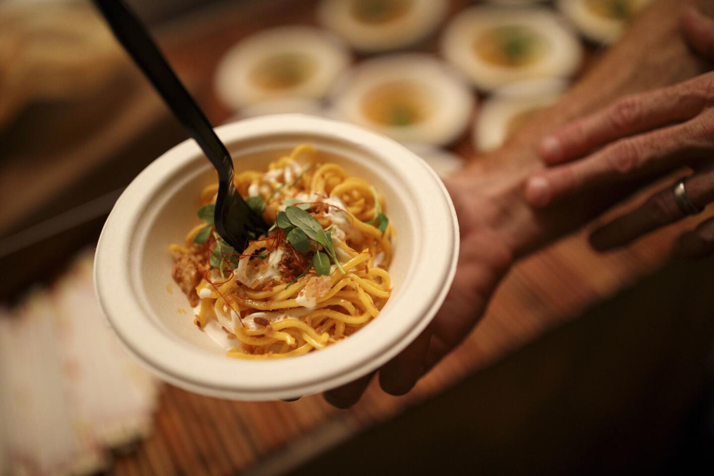 Bourbon Steak serves Palabok noodles, made with egg noodles, crab butter, "XO" crumble, Yuzu aioli, chili herbs and chicharron, at The Taste.
